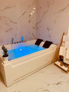 a bath tub with blue water in a bathroom at Nuvola Luxury suite in Turin
