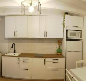 een keuken met witte kasten en een witte koelkast bij Casa Bea in Puertomingalvo