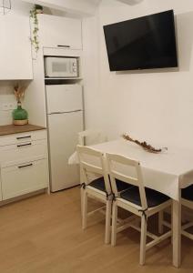 een keuken met een witte tafel en 2 stoelen bij Casa Bea in Puertomingalvo +3 foto's