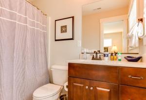een badkamer met een wastafel, een toilet en een spiegel bij 404A The Hilltop House in Virginia Beach +38 foto's