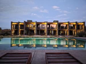 an exterior view of a building with a swimming pool at Vistalba Hotel Aparts & Suites in Ciudad Lujan de Cuyo