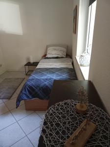a small bedroom with a bed and a window at FEWO Caro in Nordhausen