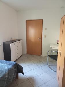 a bedroom with a door and a table and a desk at FEWO Caro in Nordhausen +1 photo