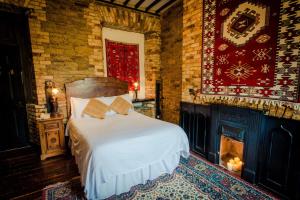 a bedroom with a bed and a brick wall at Kinnitty Castle Hotel in Kinnitty +10 photos