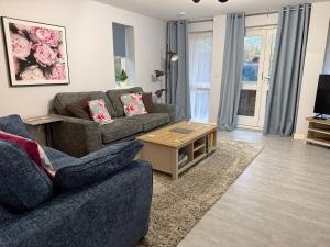 a living room with two couches and a coffee table at Superb 2 bed 2 bathroom free parking in Derby