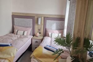 ein Schlafzimmer mit 2 Betten und einer Topfpflanze in der Unterkunft SeaView Sleeps 4to6 Pet friendly Parking in Wareham