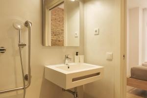 a bathroom with a white sink and a shower at GuestReady - ARIQUS Apartments in Hospitalet de Llobregat +39 photos