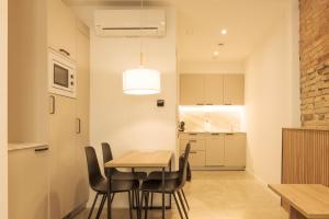 Un comedor y una cocina con mesa y sillas. en ARIQUS Apartments, en Hospitalet de Llobregat