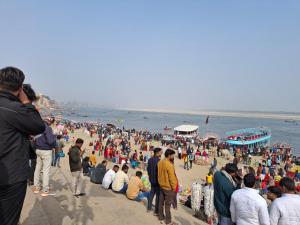 a crowd of people standing on a beach at The Light House in Varanasi
