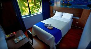 a hotel room with a bed with a blue blanket at Hotel Suite Los Inkas en Arequipa in La Pampilla