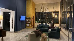 een lobby met banken en stoelen en een tv bij Flat Vila da Serra in Nova Lima