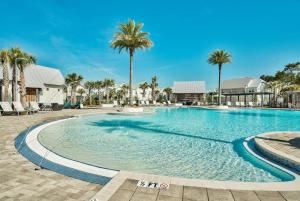 a swimming pool with palm trees in a resort at Prominence 30A - Mint Julep in Inlet Beach