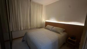 een kleine slaapkamer met een bed met een lamp erop bij Flat Vila da Serra in Nova Lima +7 foto's
