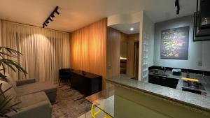 een keuken en woonkamer met een bank en een tafel bij Flat Vila da Serra in Nova Lima