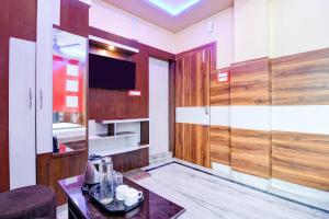 Una sala de estar con una mesa y un televisor. en Super Collection O New Jalpaiguri Railway Station Formerly Prince Lodge, en Siliguri