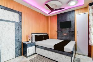 a bedroom with a bed and a ceiling fan at Super Collection O New Jalpaiguri Railway Station Formerly Prince Lodge in Siliguri