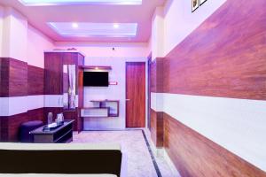 a hotel room with a television and a desk at Super Collection O New Jalpaiguri Railway Station Formerly Prince Lodge in Siliguri