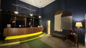 een lobby met een gele balie en een blauwe muur bij Flat Vila da Serra in Nova Lima