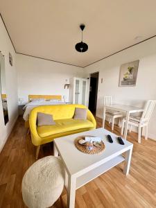 una habitación con una cama y un sofá y una mesa en Studio cosy avec balcon, en Bagnoles de l'Orne