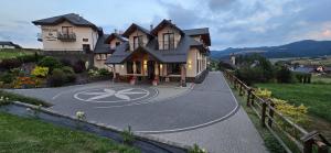 a house with a peace sign in the middle of a driveway at Pensjonat Perła Pienin in Grywałd