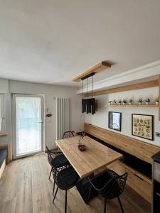a dining room with a wooden table and chairs at Fiore delle Alpi in Bellamonte