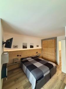 a bedroom with a large bed and a flat screen tv at Fiore delle Alpi in Bellamonte