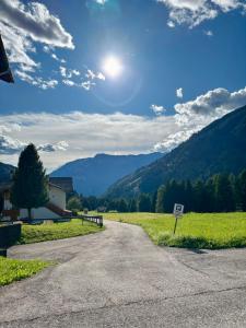 a road leading into a field with mountains in the background at Fiore delle Alpi in Bellamonte