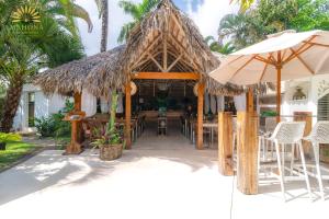 a restaurant with tables and chairs and an umbrella at Mahona Boutique Hotel in Las Terrenas