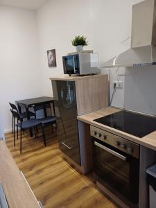 eine Küche mit Herd oberer Ofen neben einem Tisch in der Unterkunft Wohnung in Köln 3B in Köln + 2 Fotos