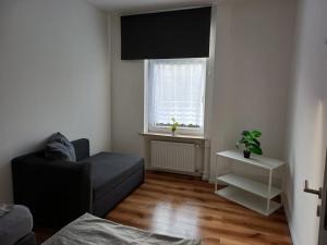 ein Wohnzimmer mit einer Couch und einem Fenster in der Unterkunft Wohnung in Köln 3B in Köln