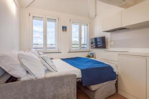 a bedroom with a large bed and two windows at Corso Adriano 13 - La Torre in Modena