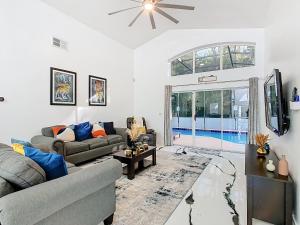een woonkamer met twee banken en een tv bij Casita mi Encanto a Cozy & Spacious House, 4-bedroom 3-Bath & pool in Kissimmee