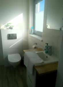 a white bathroom with a toilet and a sink at Casa Luisa - Trzęsacz in Trzęsacz