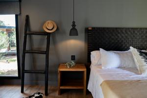 a bedroom with a bed and a hat on a table at Lun Lodges in Ciudad Lujan de Cuyo