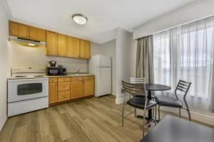 a kitchen with wooden cabinets and a table and chairs at Best Western Pier Point Inn in Florence