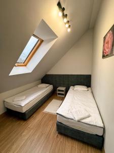 a bedroom with two beds in a attic at Apartamenty Brzozowe in Okoniny Nadjezierne