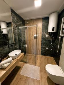 a bathroom with two toilets and a glass shower at Apartamenty Brzozowe in Okoniny Nadjezierne