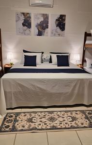 サンタ・フェ・ド・スルにあるRubi casa de temporada com piscina e área gourmetのベッドルーム1室(大型ベッド1台、青い枕、ラグ付)