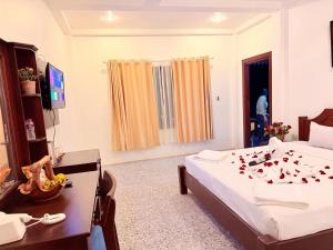 a bedroom with a bed and a table with hearts on it at Vang Vieng Ruby Villa Hotel in Vang Vieng