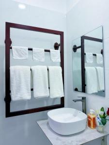 a bathroom with a sink and a mirror and towels at Vang Vieng Ruby Villa Hotel in Vang Vieng