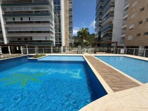 a large swimming pool in front of some buildings at cód 63 · Apartamento sofisticado com 2 suítes! in Governador Celso Ramos +28 photos
