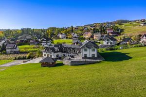 an aerial view of a large house on a green field at Pensjonat Perła Pienin in Grywałd