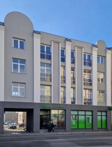 a large building with a person walking in front of it at Apartament Podniebny z Windą in Kluczbork