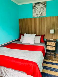 a bedroom with a bed with a tiger picture on the wall at Ewakanda Backpackers in Vereeniging