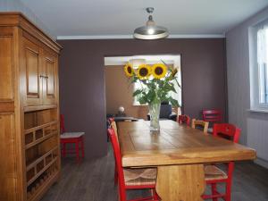 a dining room with a table with a vase of sunflowers at Gîte du Soleil - close to Europa-Park in Grussenheim
