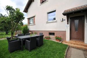 a table and chairs in the yard of a house at Gîte du Soleil - close to Europa-Park in Grussenheim