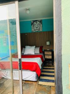 a bedroom with a bed with a lion on the wall at Ewakanda Backpackers in Vereeniging +26 photos