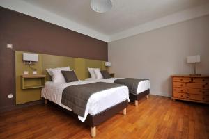 GrussenheimにあるGîte du Soleil - close to Europa-Parkのベッド2台が備わるウッドフロアの客室です。