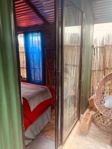 a room with a bed and a glass door at Ewakanda Backpackers in Vereeniging