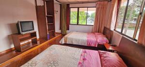 a small room with two beds and a tv at Casa del Pino in Popayan +8 photos
